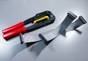 Two freshly made, complete IDC ribbon cables of different lengths lying on a workbench.