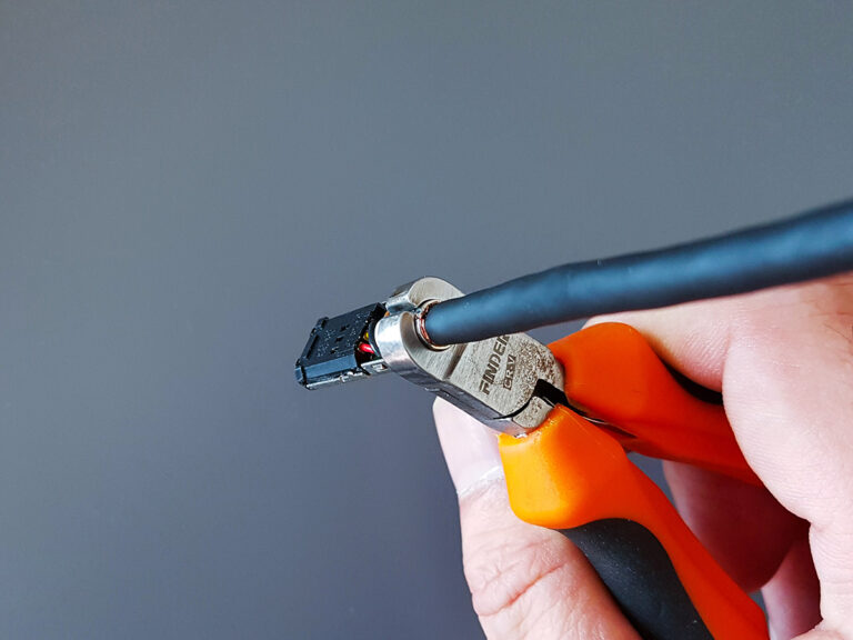 The modified tool jaws fully closing and applying pressure to the shield crimp barrel