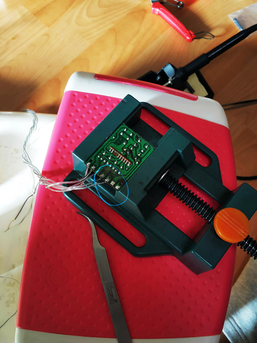 The glue blob removed, exposing the bare, poorly soldered wire connections.