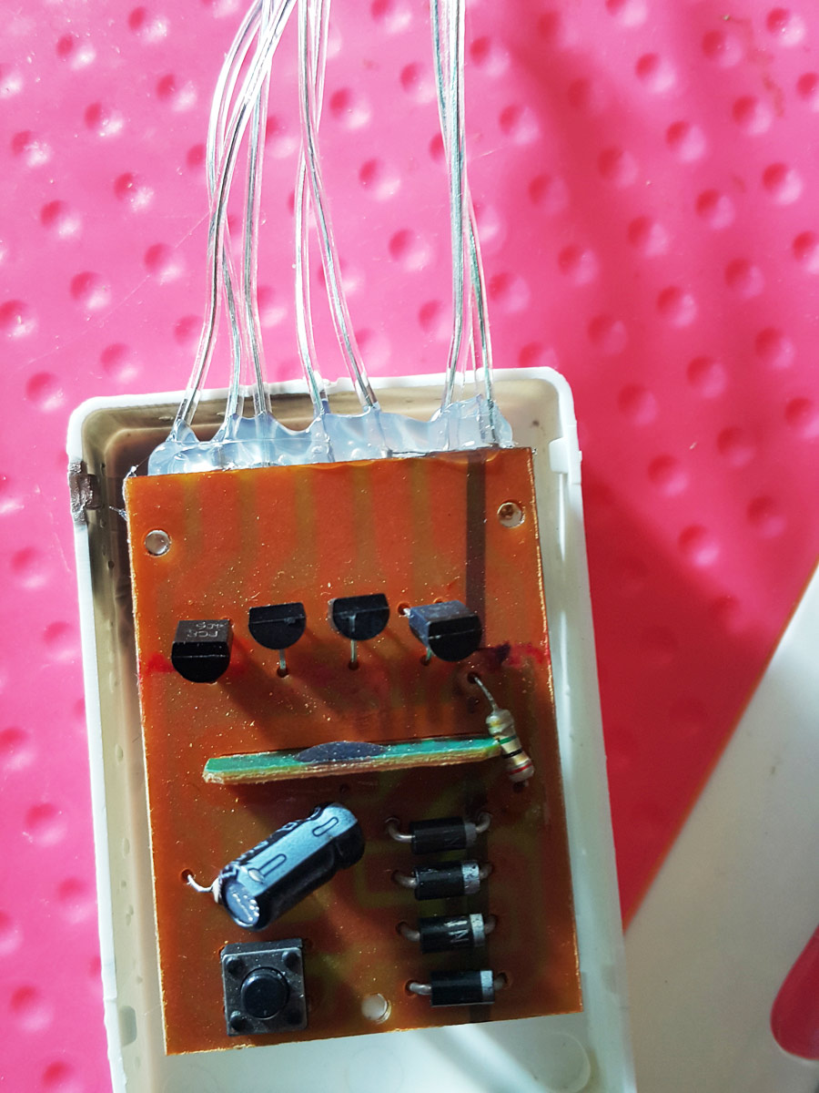 The underside of the board also showing generous application of hot glue around wire entry points.