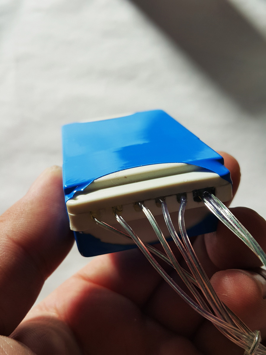 The assembled controller housing tightly wrapped in a piece of blue shrink film.