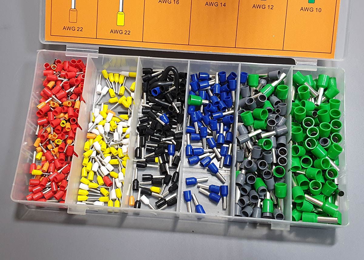 An open plastic case filled with various sizes and colors of ferrule terminals.