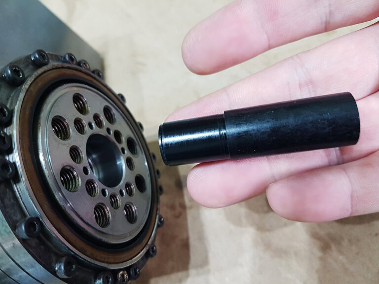 The custom-machined black Acetal (POM) alignment jig, held in hand.