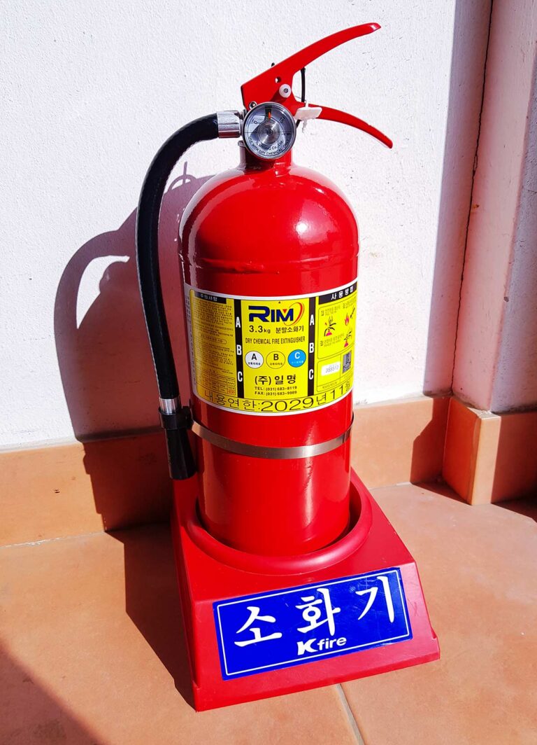 A fire extinguisher conveniently placed near a home entrance for easy access.