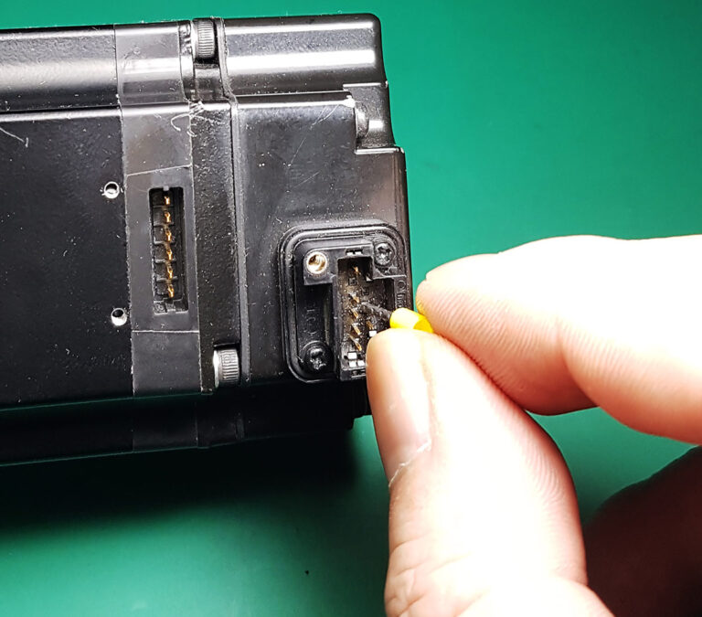 The ferrule terminal being carefully slid over the bent encoder pin to guide it back into a straight position.