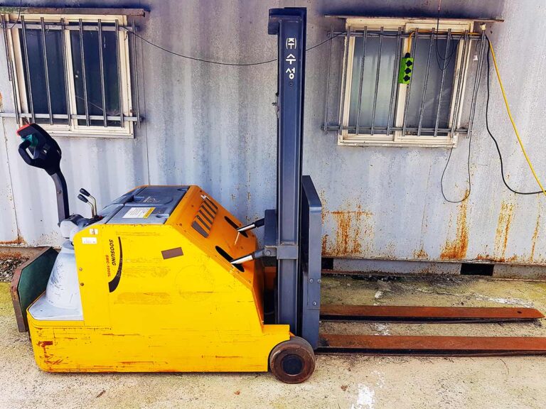 The electric forklift (Soosung SWC-1000L) parked outside the workshop.