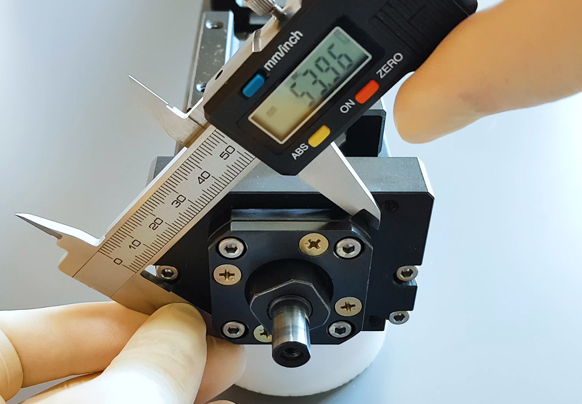 Measuring the actuator support unit with digital calipers.