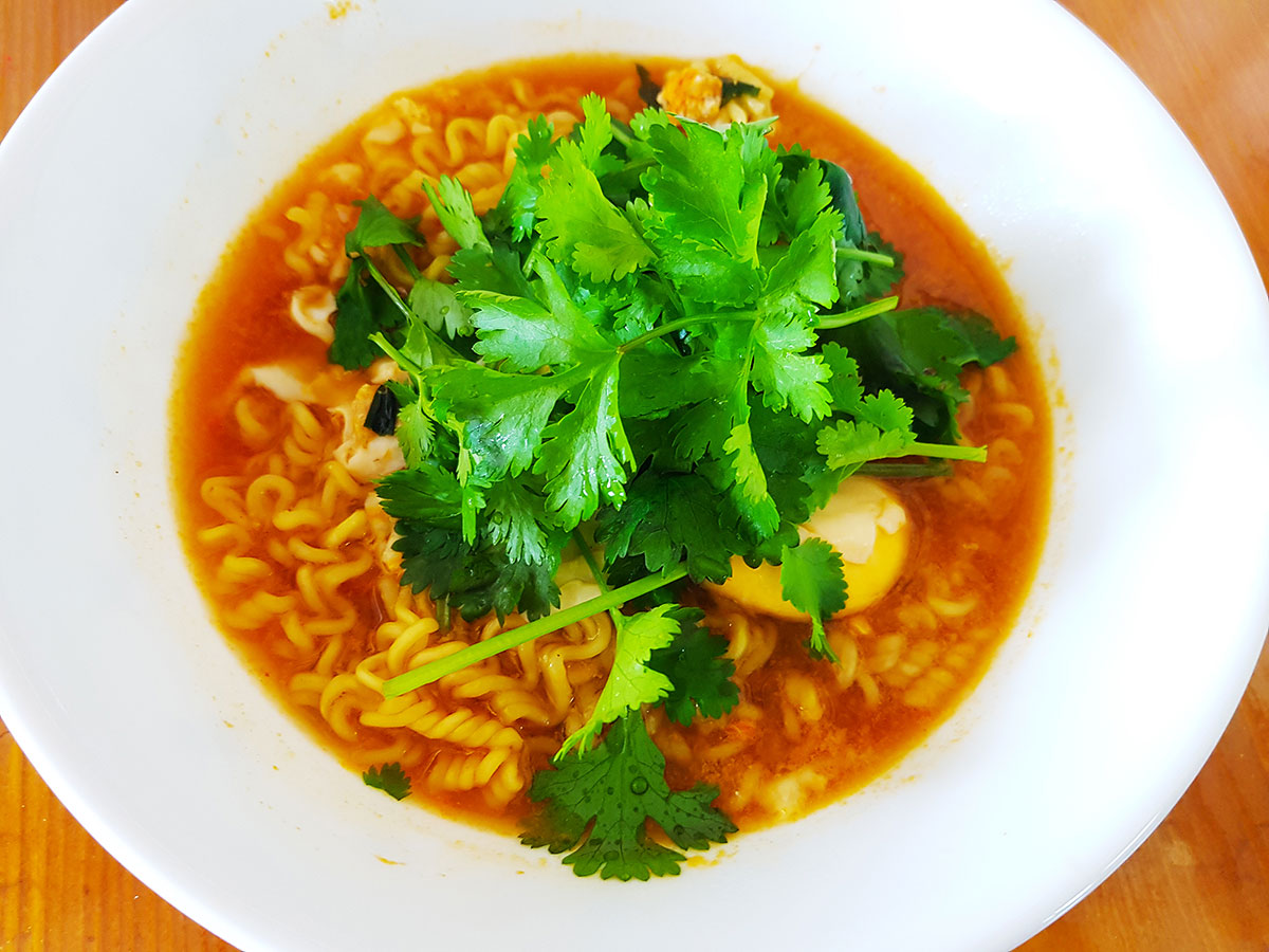 A bowl of instant ramen topped with freshly harvested coriander.